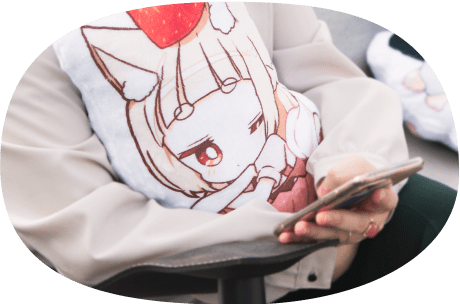 ふかふかクッションを抱えながらスマホを見る人の写真