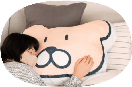 ふかふかクッションを枕にして眠る人の写真